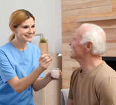 Caregiver feeding elderly